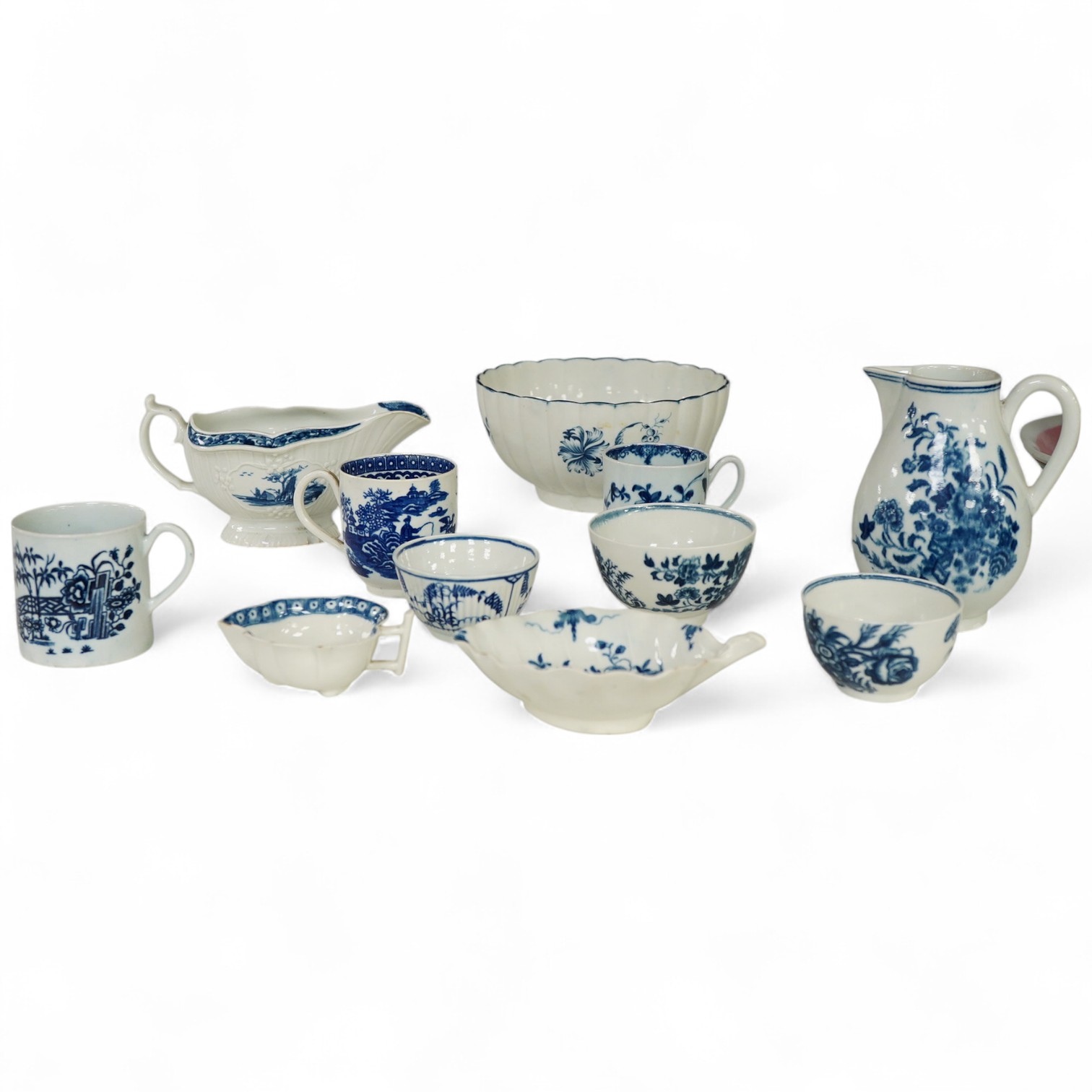 A collection of first period Worcester blue and white porcelain to include a Fence pattern sparrow-beak jug, a fluted Gilly-flower pattern bowl, a peony rock bird scallop shell pickle dish, a butter boat, a fisherman and